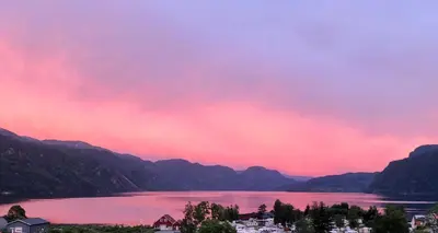 a view of a lake with a pink sky at Sauda Fjordhotell in Saudasjøen