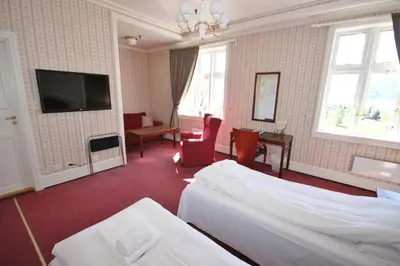 a hotel room with a bed and a tv at Sauda Fjordhotell in Saudasjøen