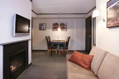 a living room with a couch and a table with a television at Alpin Apartments Sørlia in Hafjell