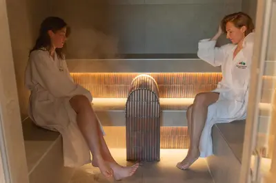 two women sitting on a bench with a heater at Panorama Hotell & Resort in Steinsland