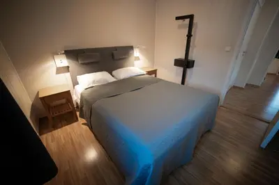a bedroom with a large bed with a blue blanket at Førde Gjestehus og Camping in Førde