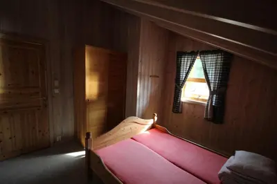 a bedroom with a red bed with a window at Bratland Camping in Bergen
