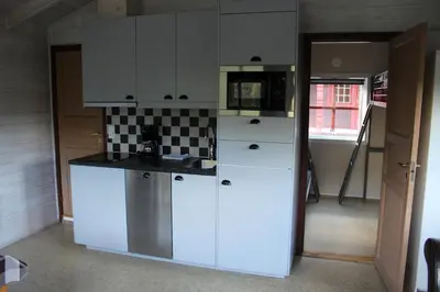 a kitchen with white cabinets and a sink at Bratland Camping in Bergen