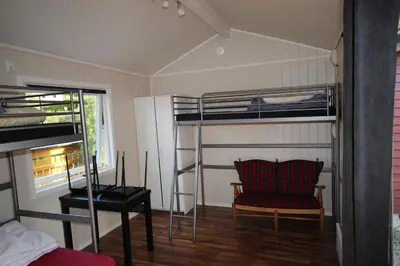 a room with bunk beds and a chair and a desk at Bratland Camping in Bergen