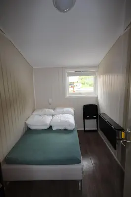 a small room with two beds and a window at Bratland Camping in Bergen