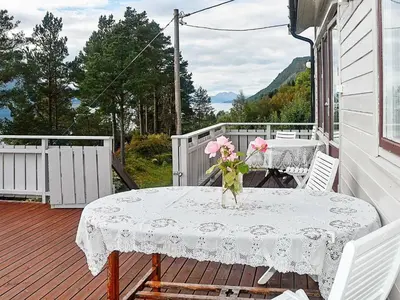 a table with a vase of flowers on a porch at 8 person holiday home in EIDSVÅG-By Traum in Mittet