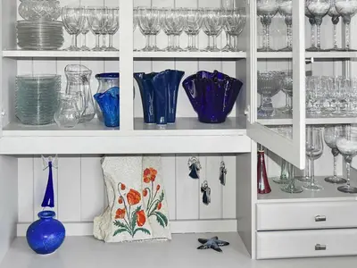 a white cabinet filled with lots of glasses and vases at 8 person holiday home in EIDSVÅG-By Traum in Mittet