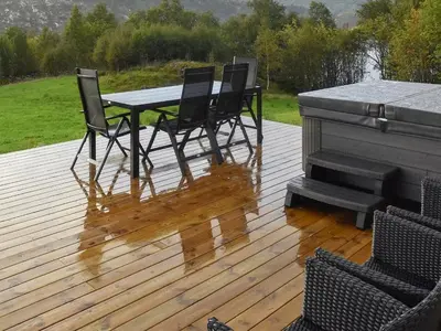 a wooden deck with a table and chairs and a piano at 8 person holiday home in Masfjordnes-By Traum in Masfjorden
