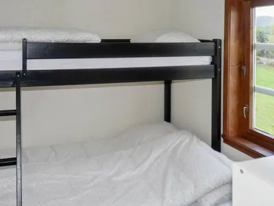 two bunk beds in a room with a window at 8 person holiday home in Masfjordnes-By Traum in Masfjorden