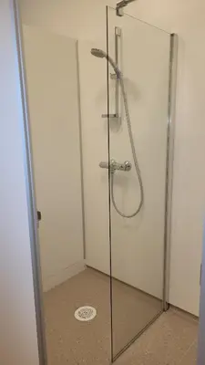 a shower with a glass door in a bathroom at Øen Turistsenter Cottages in Geilo