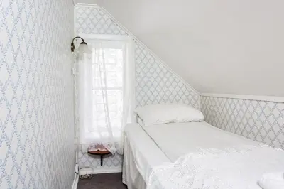 a small bedroom with a bed and a window at Jaunsen Gjestgjevarstad in Granvin