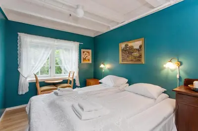 two beds in a room with blue walls at Jaunsen Gjestgjevarstad in Granvin