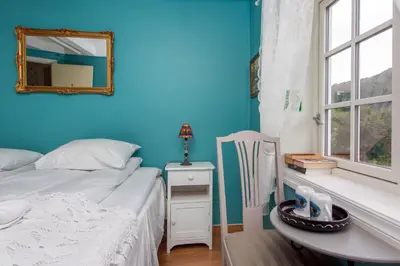 a bedroom with a bed and a mirror and a table at Jaunsen Gjestgjevarstad in Granvin