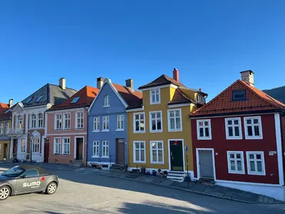 a car parked in front of a row of colorful houses at Klosterhagen Hotel in Bergen