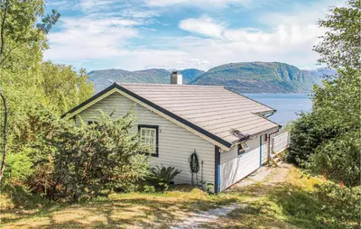 a small white house next to a body of water at 3 Bedroom Cozy Home In Lavik in Lavik