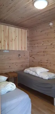 a bedroom with two beds in a wooden wall at Stalheim Fjord og Fjellhytter in Stalheim