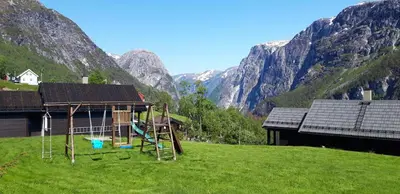 a playground in a field with mountains in the background at Stalheim Fjord og Fjellhytter in Stalheim
