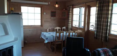 a dining room with a table and chairs and windows at Stalheim Fjord og Fjellhytter in Stalheim