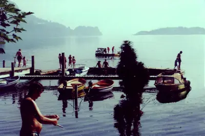 a group of people on a dock with boats in the water at Hardanger Feriesenter Nesvika in Norheimsund