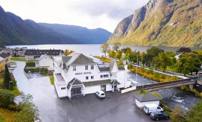 an aerial view of a large white building next to a lake at Øren Hotel in Høyanger