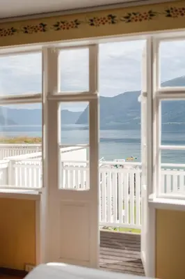 a room with a window looking out at the ocean at Leikanger Fjordhotel - Unike Hoteller in Leikanger
