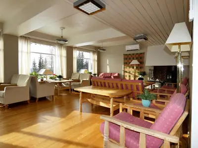 a living room with tables and chairs and a table at Tronsvangen Seter in Alvdal