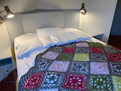 a bed with a colorful quilt on it in a room at Eikum Hotel in Hafslo