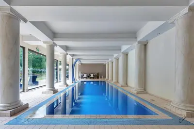 a swimming pool with columns and blue water at Nordfjord Hotell in Nordfjordeid