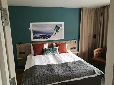 a bedroom with a bed with a snowboard on the wall at Nordfjord Hotell in Nordfjordeid