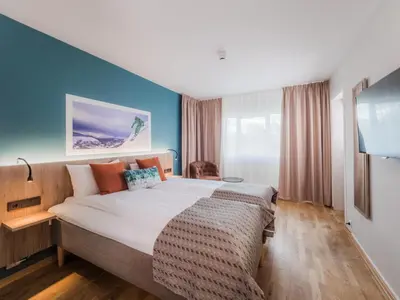 a bedroom with a large bed with a blue wall at Nordfjord Hotell in Nordfjordeid