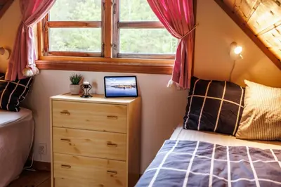 a bedroom with a bed and a window at Eastside Cottages in Bømlo
