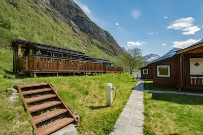 a train station with a mountain in the background at Grande Hytteutleige og Camping in Geiranger