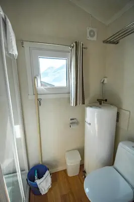 a small kitchen with a refrigerator and a window at Grande Hytteutleige og Camping in Geiranger
