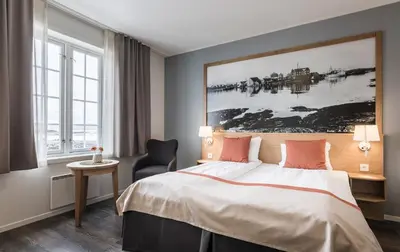 a hotel room with a bed and a painting on the wall at Finnøy Bryggehotell - by Classic Norway Hotels in Finnøy