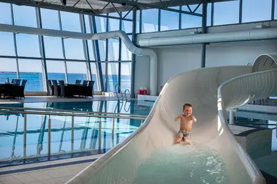 a young boy on a slide in a swimming pool at Finnøy Bryggehotell - by Classic Norway Hotels in Finnøy