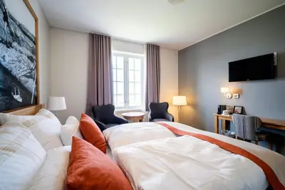 a hotel room with a bed and a flat screen tv at Finnøy Bryggehotell - by Classic Norway Hotels in Finnøy