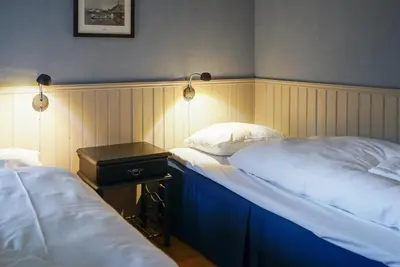 two twin beds in a room with a night stand at Ona Havstuer - by Classic Norway Hotels in Ona