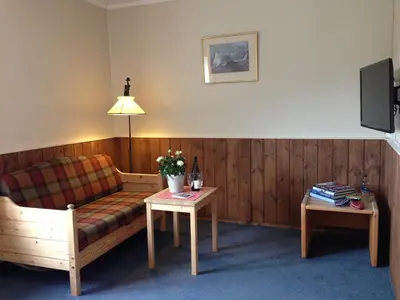 a living room with a couch and a table at Fossheim Hotel Lom in Lom