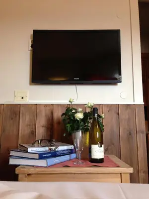 a table with books and a bottle of wine and a glass at Fossheim Hotel Lom in Lom