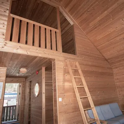 a wooden room with a ladder in the ceiling at Grandane Feriehus in Stongfjorden