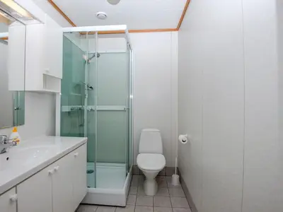 a bathroom with a toilet and a glass shower at Grandane Feriehus in Stongfjorden