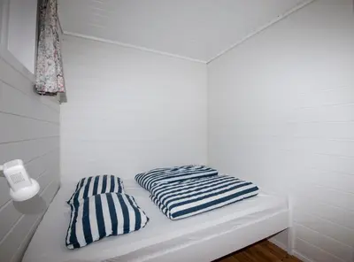a white room with two striped pillows on a bed at Grandane Feriehus in Stongfjorden
