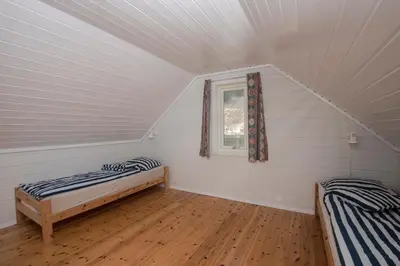 a room with two beds and a window at Grandane Feriehus in Stongfjorden