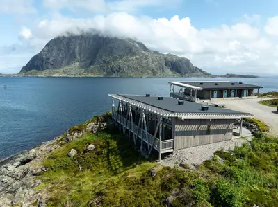 a house on the edge of a body of water at Værlandet Havhotell in Hamna