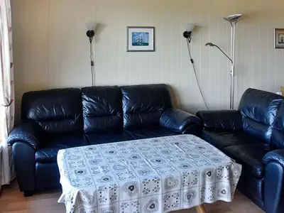 a living room with a black leather couch with a table at 6 person holiday home in Aukra in Aukra