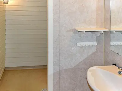 a bathroom with a sink and a glass shower at 6 person holiday home in Aukra in Aukra
