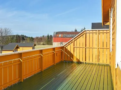 a balcony with a yellow railing and a wooden deck at 6 person holiday home in Aukra in Aukra