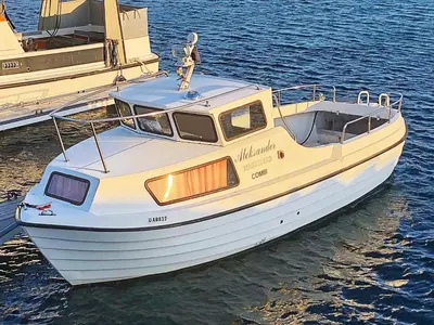 a white boat is docked in the water at 6 person holiday home in Aukra in Aukra