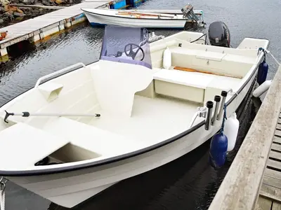 a white boat is docked at a dock at 6 person holiday home in Aukra in Aukra