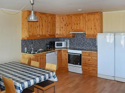 a kitchen with wooden cabinets and a white refrigerator at 6 person holiday home in Aukra in Aukra